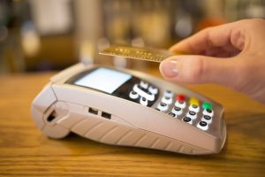 Woman paying with NFC technology on credit card, restaurant, shop